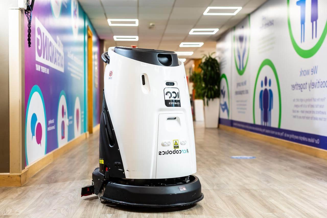 Mitie black-and-white cleaning robot in a corridor