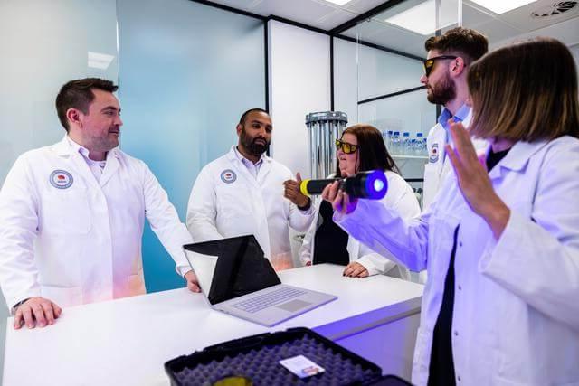 Mitie staff in a lab environment demonstrating UV cleaning 科技niques